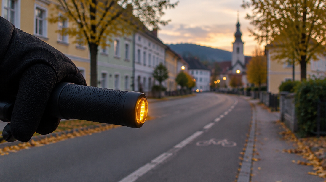 E-Scooter Blinkerpflicht in Österreich: gelber LED-Blinker am Lenkerende in einer Ortsstraße in der Abenddämmerung